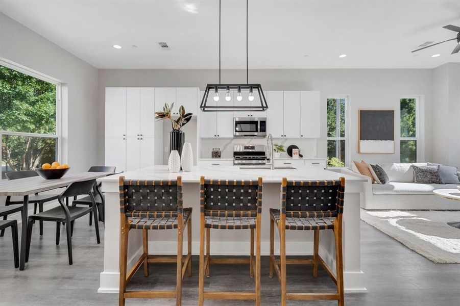 Kitchen with white cabinetry, range with gas cooktop, ceiling fan, and a wealth of natural light