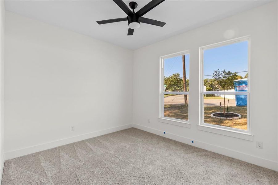 Unfurnished room featuring carpet floors and ceiling fan