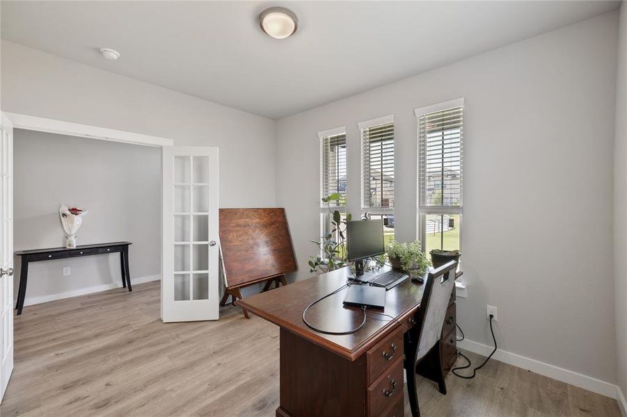 Office with light hardwood / wood-style flooring