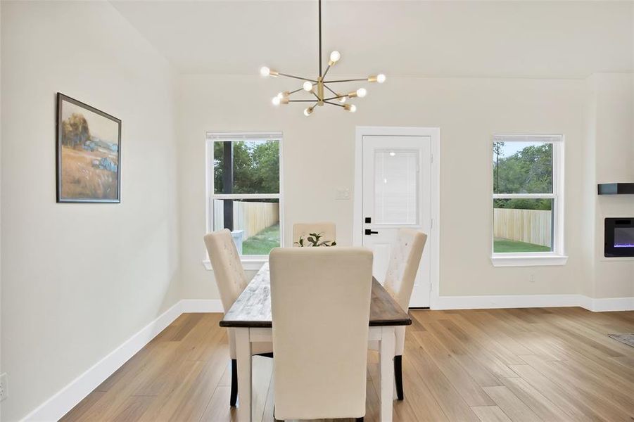 Dining room featuring plenty of natural light, a chandelier, and light hardwood / wood-style floors