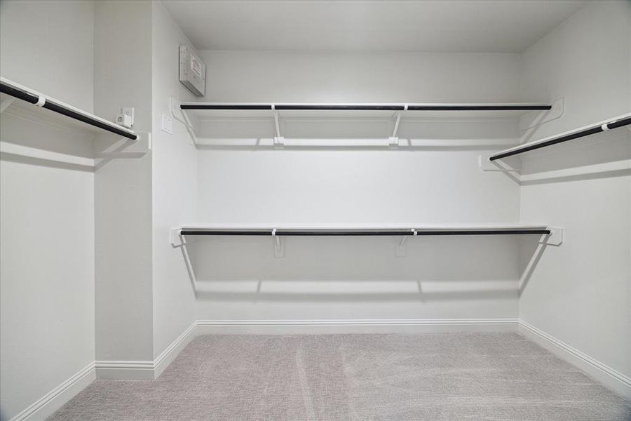 This walk-in closet in the primary bedroom provides abundant hanging space and shelving for organized storage, offering plenty of room to keep your wardrobe and accessories neatly arranged.