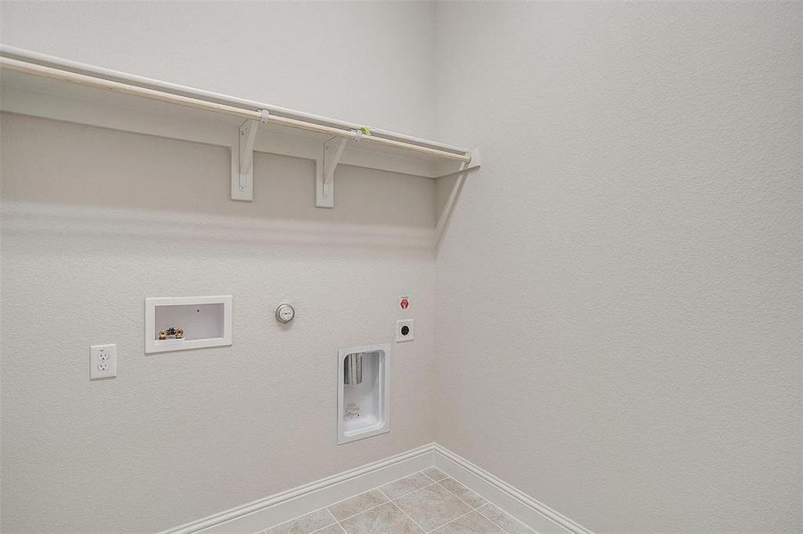 Washroom featuring hookup for a washing machine, gas dryer hookup, electric dryer hookup, and light tile patterned floors