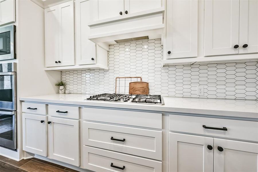 The kitchen features white cabinets,creating a clean and timelessaesthetic.