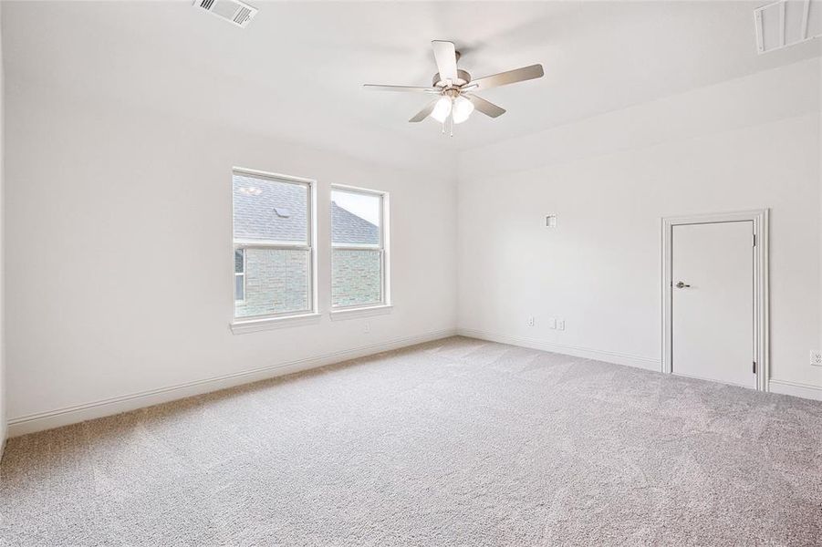 Carpeted spare room featuring ceiling fan