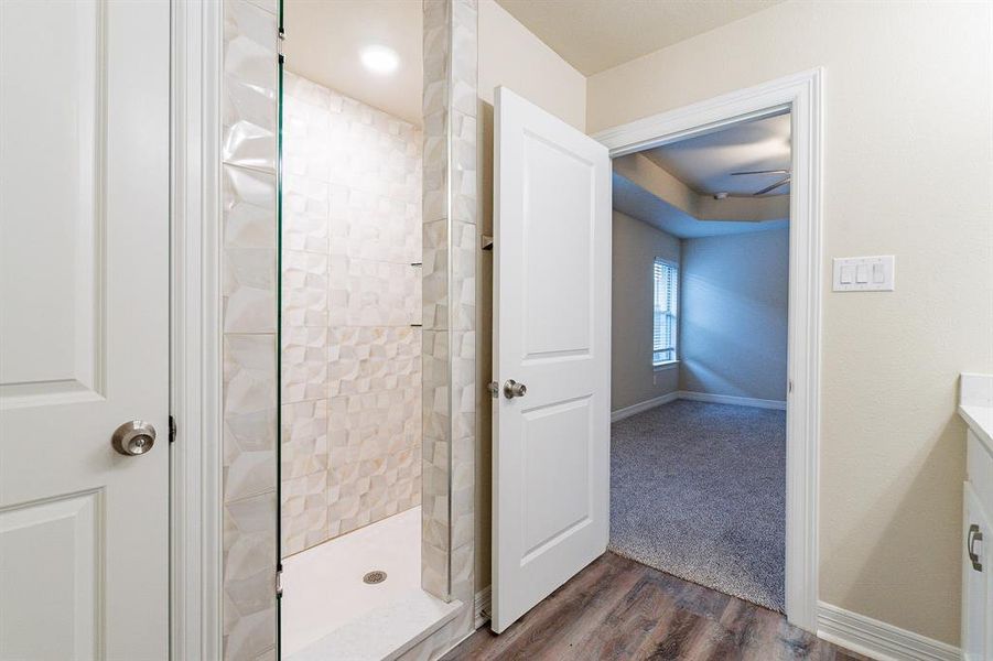 En suite Bathroom with tiled shower and hardwood / wood-style flooring