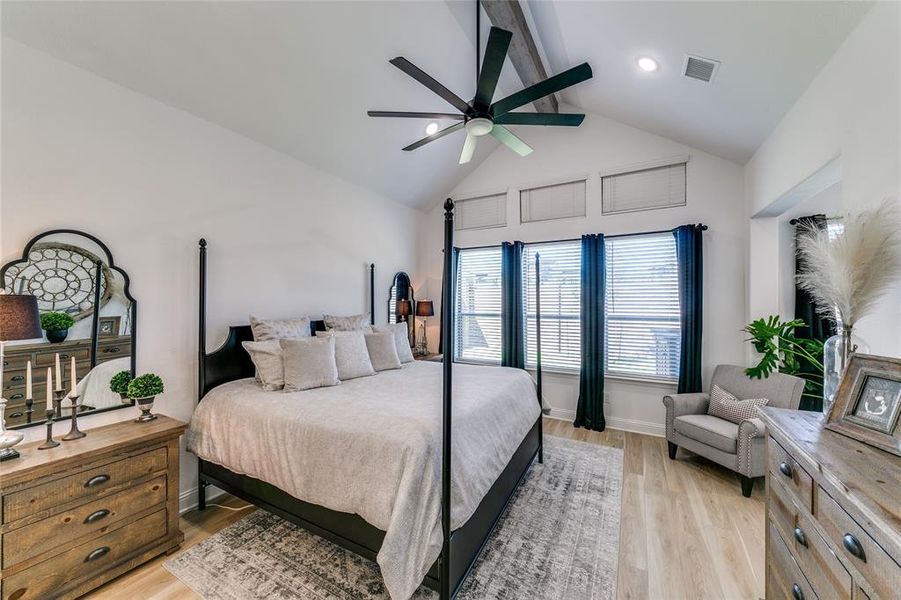 Bedroom with ceiling fan, high cathedral ceiling, beam ceiling, and light hardwood / wood-style floors