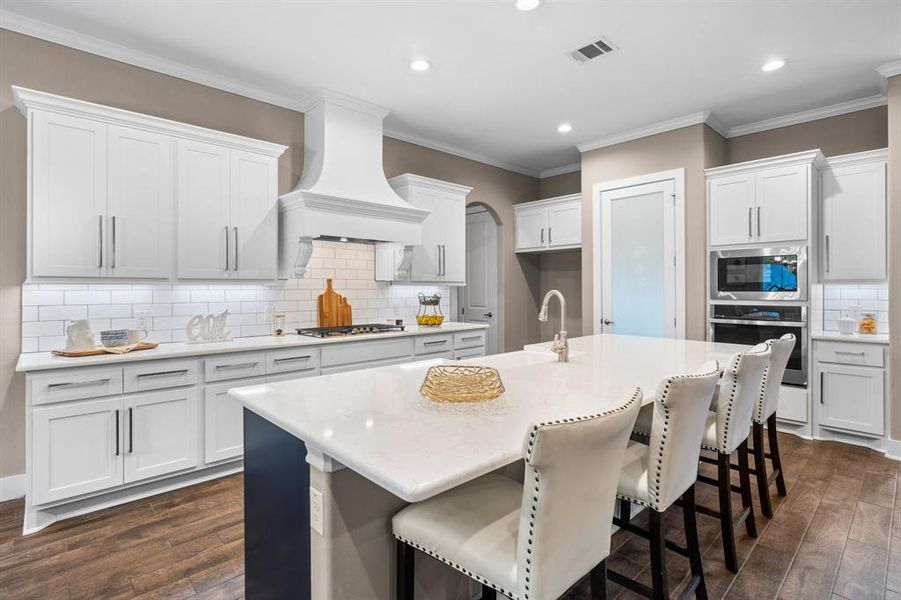 What a great place to cook or just hang out when others are cooking and enjoy their company.  Enjoy the stunning quartz countertops that provide ample workspace, complemented by a chic white subway tile backsplash that adds a touch of elegance.