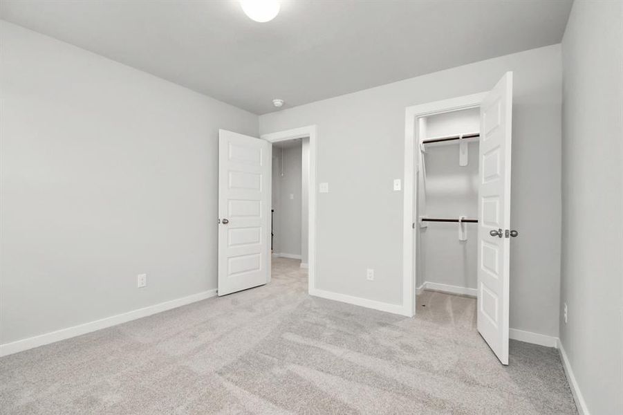 Generously sized secondary bedrooms featuring spacious closets, soft and inviting carpeting underfoot, large windows allowing plenty of natural light, and the added touch of privacy blinds for your personal retreat. Sample photo of completed home with similar floor plan. As-built interior colors and selections may vary.