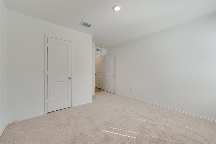 Unfurnished bedroom with light colored carpet