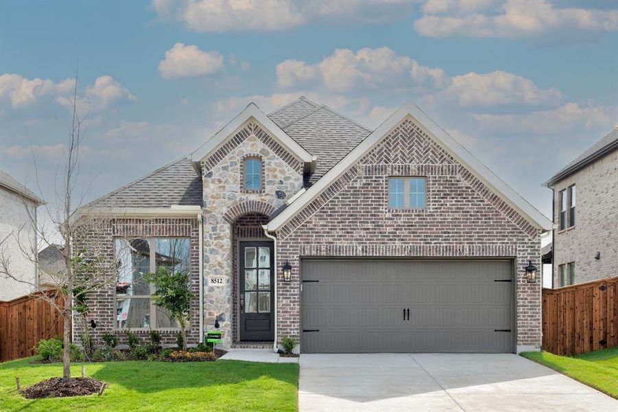 View of front of home featuring a garage and a front lawn