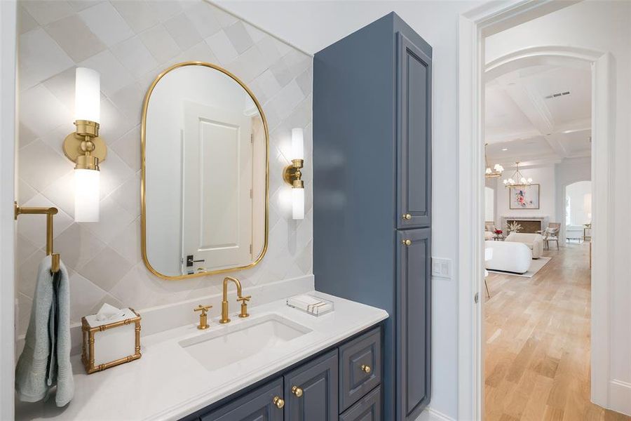 Bathroom with beam ceiling, a notable chandelier, vanity, coffered ceiling, and wood flooring