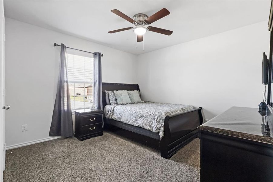 Carpeted bedroom with ceiling fan