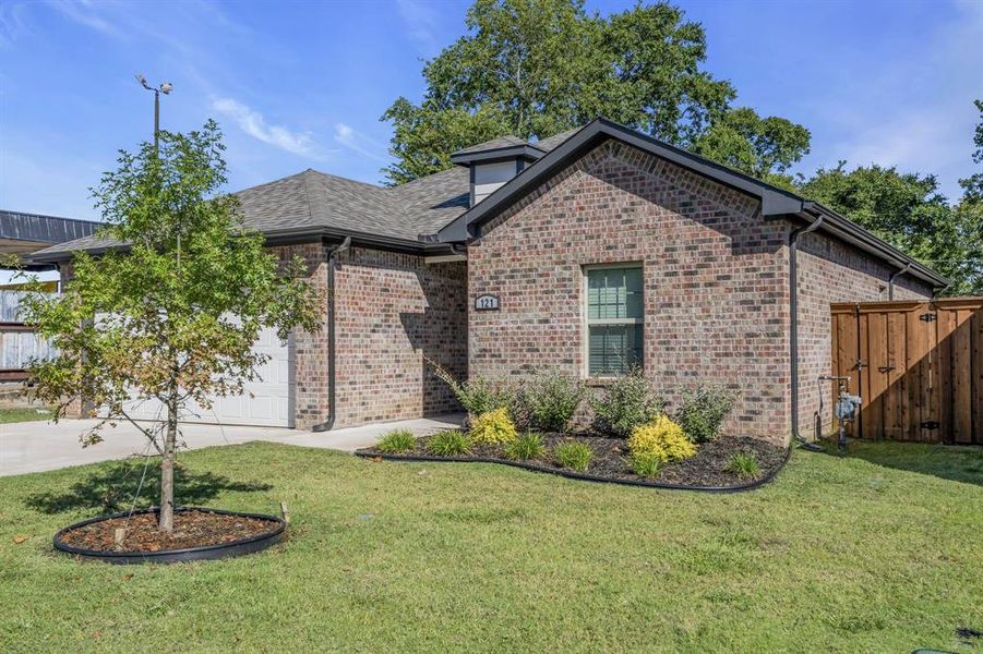 View of front of property featuring a front lawn and a garage