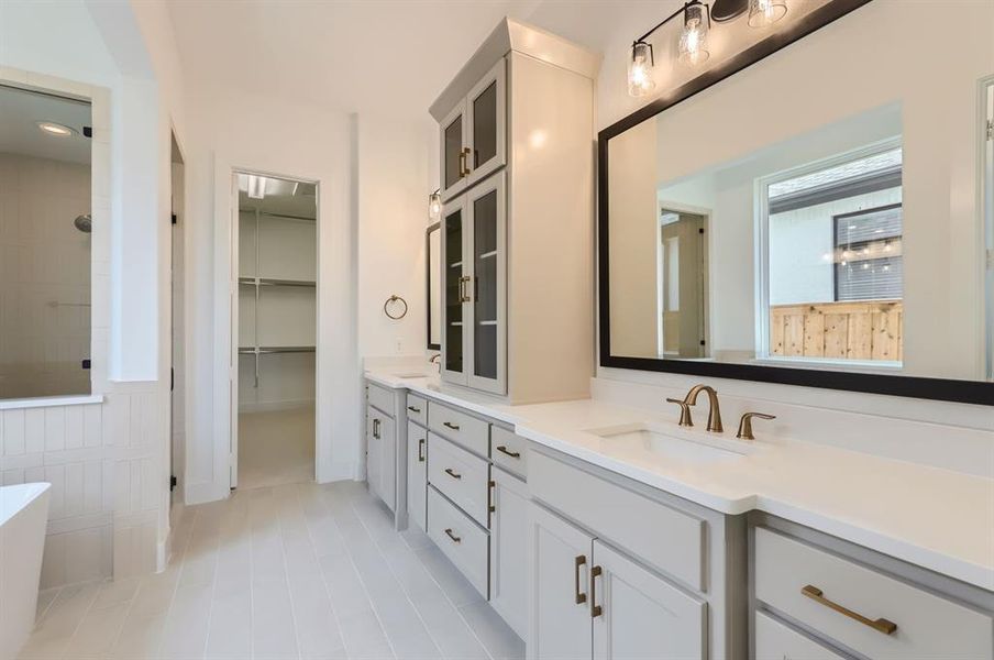 Bathroom with dual bowl vanity, tile walls, a bathing tub, and tile patterned flooring