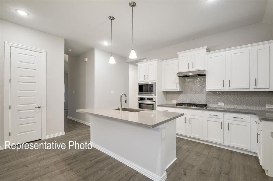 Kitchen featuring appliances with stainless steel finishes, dark wood-type flooring, and white cabinetry