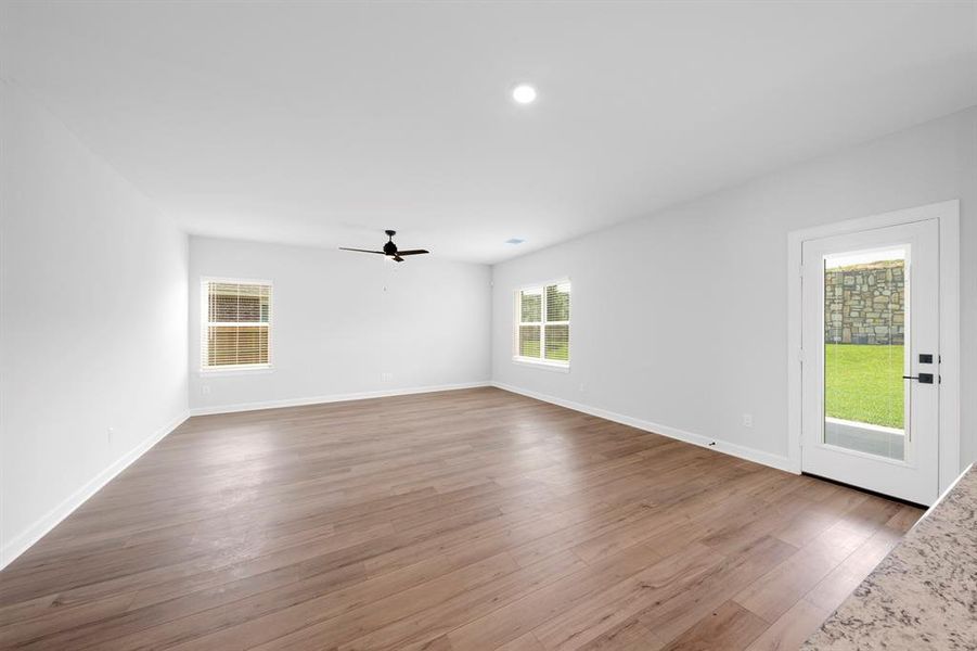 The living room is very bright, spacious and open due to the many windows and upgraded vinyl plank flooring.
