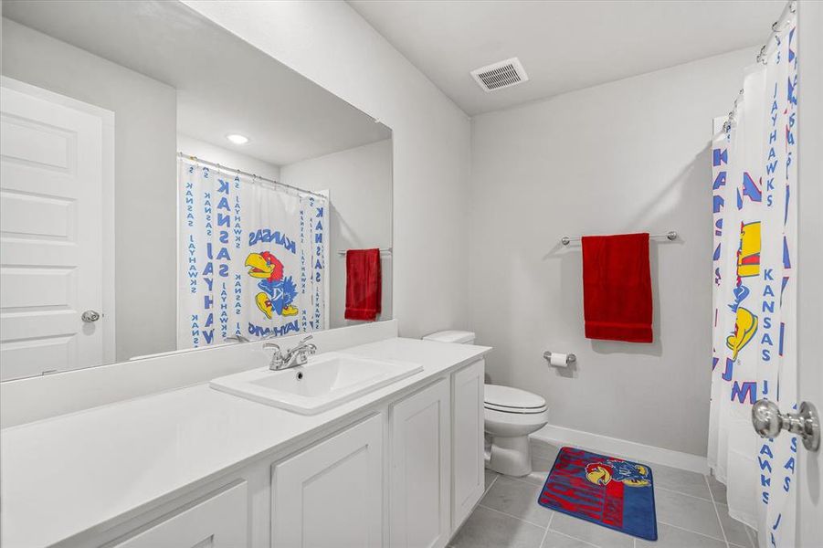 Bathroom with vanity, toilet, and tile floors