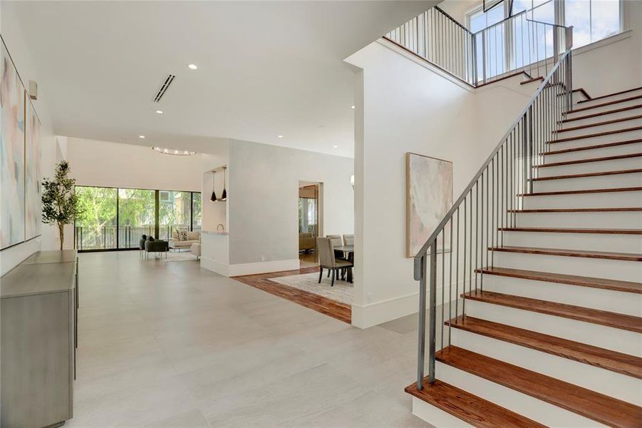 Beautiful imported Italian tiles, Brazilian Walnut flooring & stairway featuring a beautiful chandelier and sleek, modern handrails.