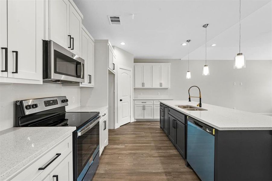 Kitchen featuring appliances with stainless steel finishes, sink, pendant lighting, dark hardwood / wood-style floors, and white cabinetry