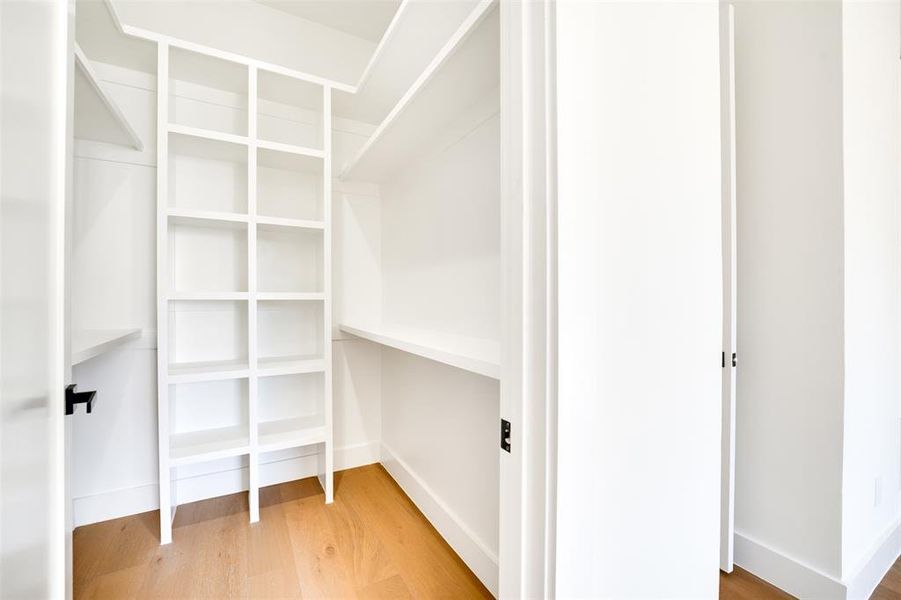 Spacious closet with hardwood / wood-style flooring