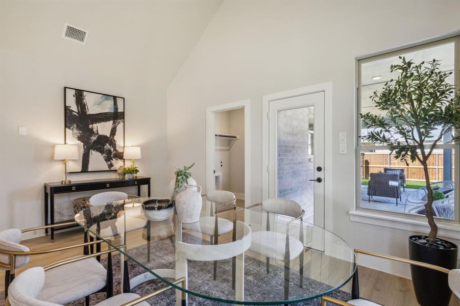 Living area with hardwood / wood-style flooring and high vaulted ceiling