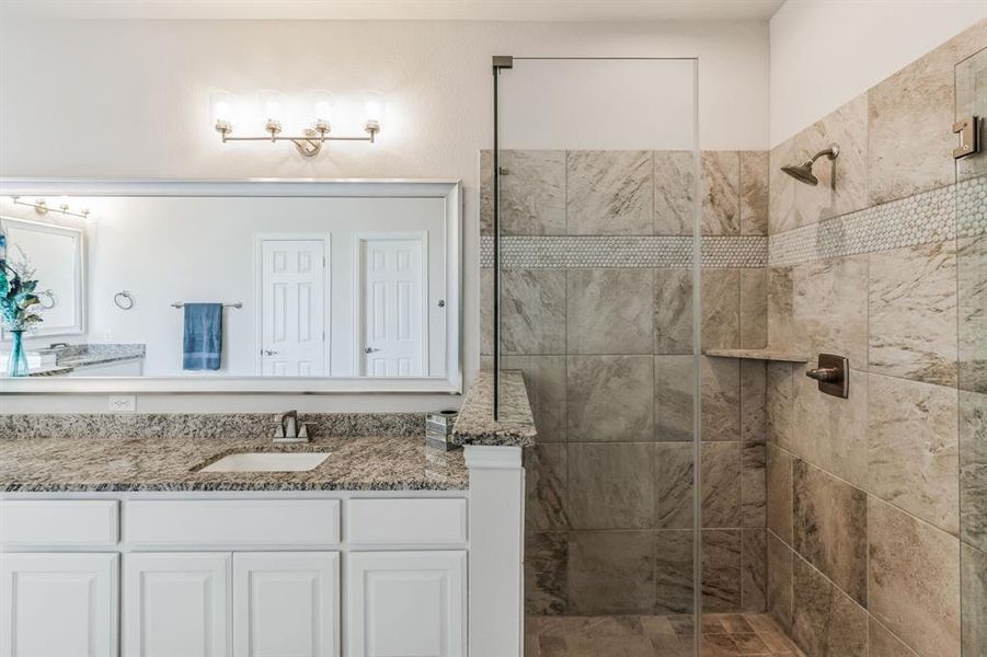 Bathroom with vanity and a tile shower
