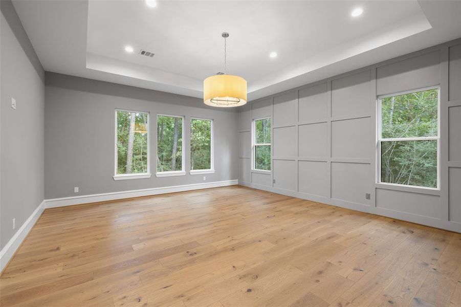 The Primary Bedroom is private and overlooks the woods! A custom feature wall and a tray ceiling enhance the ambiance.