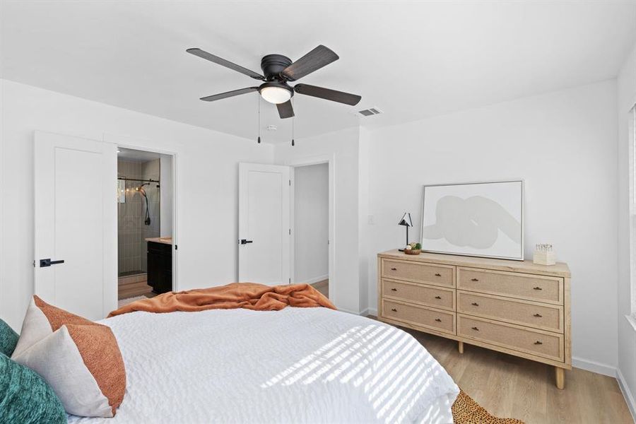 Bedroom featuring connected bathroom, light wood-type flooring, and ceiling fan