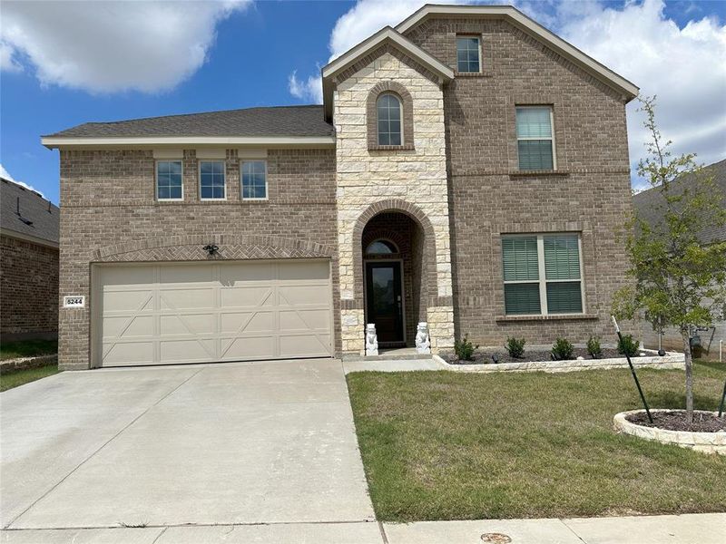 View of front of home featuring a garage and a front yard