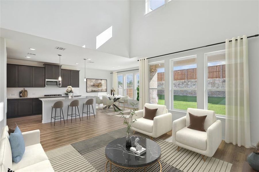 Living room featuring a high ceiling, hardwood / wood-style floors, and a skylight