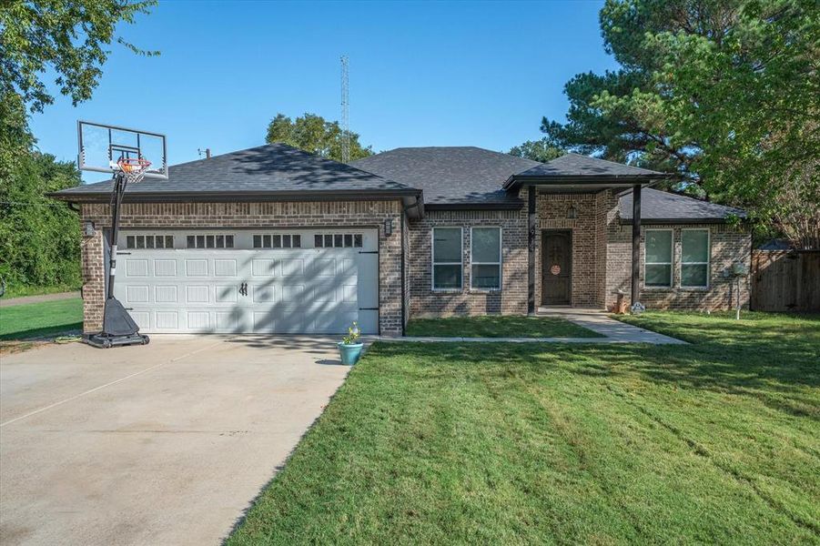 View of front of house featuring a garage and a front lawn