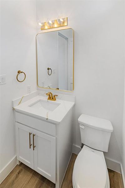 Bathroom with toilet, hardwood / wood-style floors, and vanity