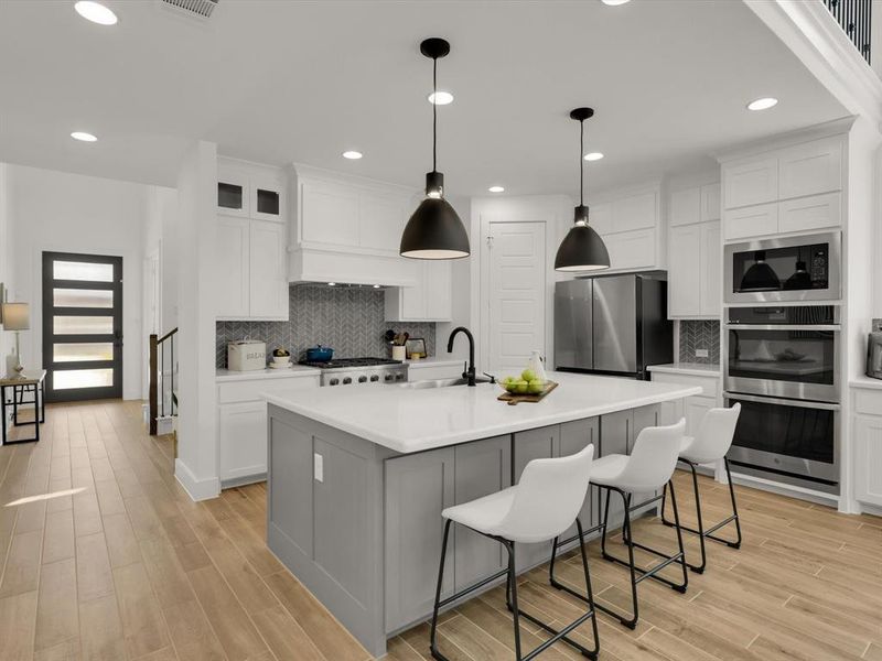 Modern kitchen with oversized island, double oven, and spacious corner pantry.