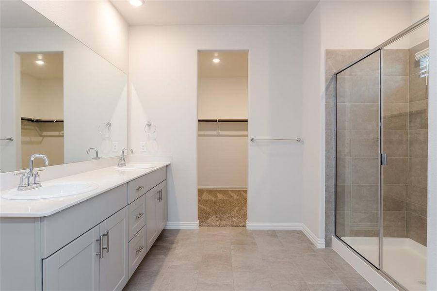 Bathroom with tile patterned flooring, vanity, and a shower with shower door