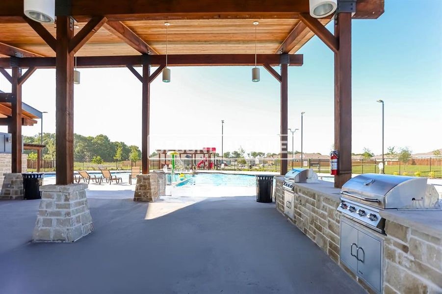 View of patio with an outdoor kitchen, grilling area, and a community pool