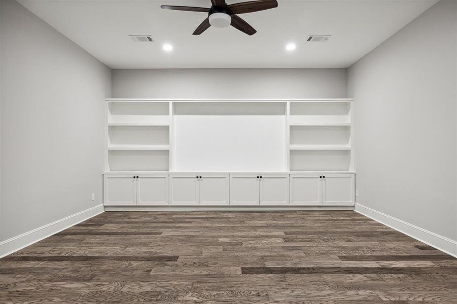 Media Room with built-in shelves, cabinetry and media display