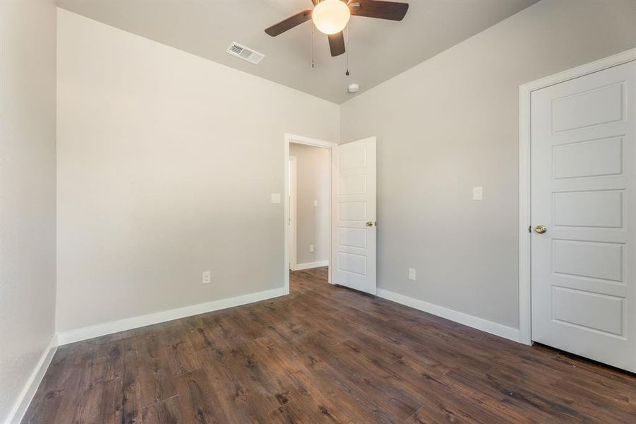 Empty room with lofted ceiling, ceiling fan, and dark hardwood / wood-style floors