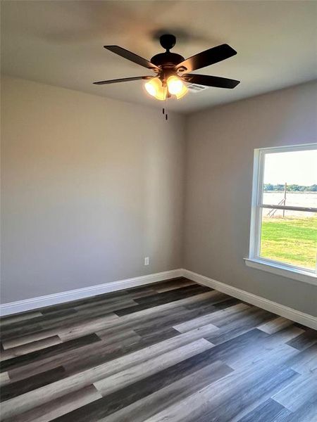 Unfurnished room featuring ceiling fan and dark wood-type flooring