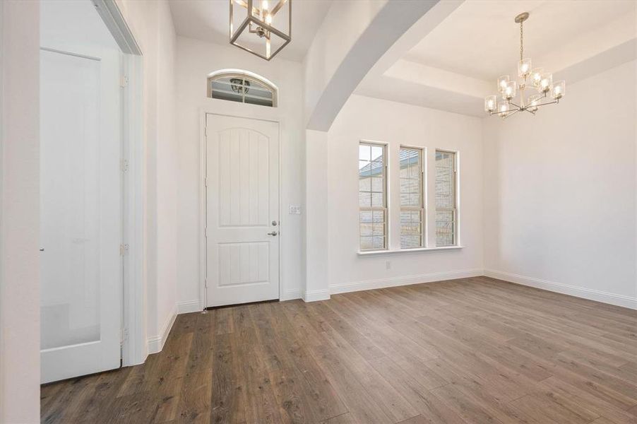 Entrance foyer featuring a notable chandelier and dark hardwood / wood-style flooring