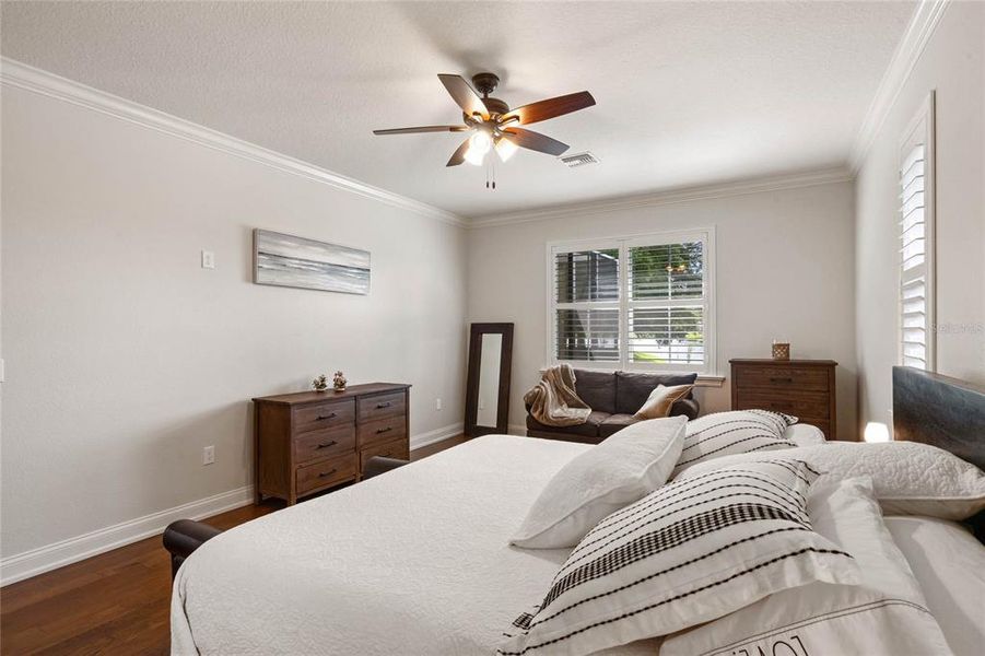 Primary Suite with Wood Flooring, Ceiling Fan & Crown Molding