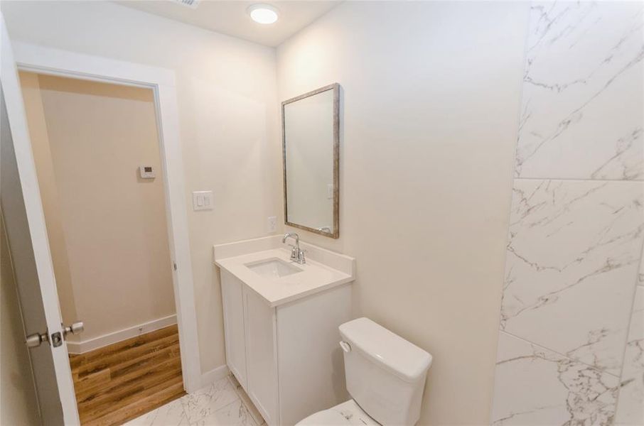 Bathroom with wood-type flooring, vanity, and toilet