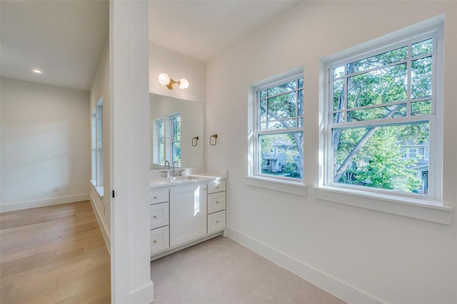 Bathroom with hardwood / wood-style floors, plenty of natural light, and vanity