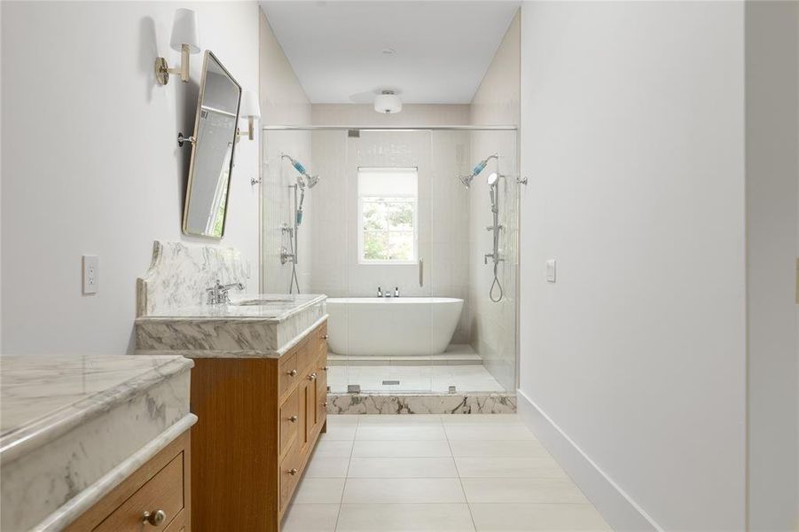Bathroom with vanity with extensive cabinet space, independent shower and bath, and tile floors