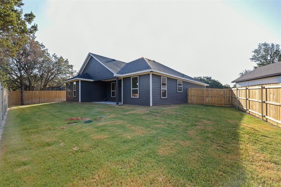 Back of house with a yard and a patio area