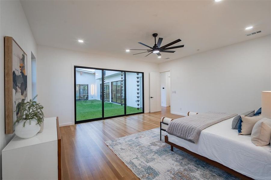 Bedroom with ceiling fan, wood-type flooring, and access to outside