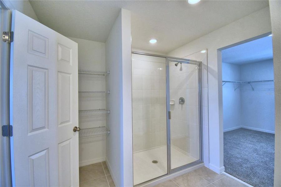 owner's en suite showing storage, shower and oversized walk-in closet