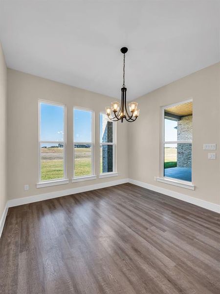 Spare room featuring hardwood / wood-style flooring and a chandelier