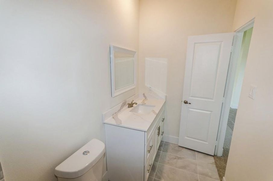 Bathroom with tile patterned flooring, toilet, and vanity