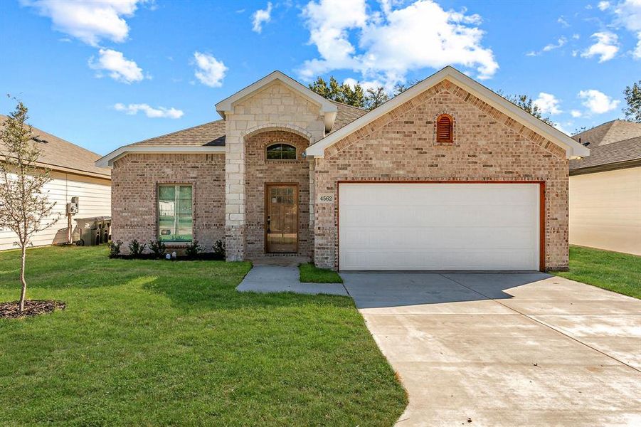 View of front of home with a front yard and a garage