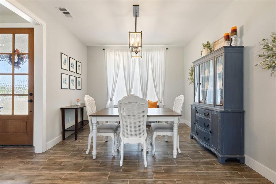 Dining room with an inviting chandelier and dark hardwood / wood-style flooring